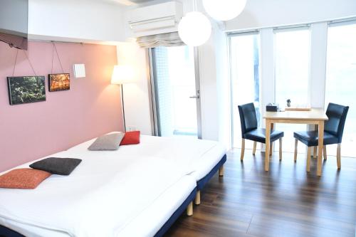 1 dormitorio con 1 cama, mesa y sillas en Hotel Axas Nihonbashi en Tokio