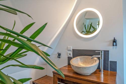 a bathroom with a bowl on a wooden table with a plant at Villa Sur le Port in Roscoff
