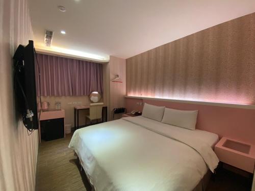 een slaapkamer met een groot wit bed in een kamer bij 191 Hotel in Taoyuan