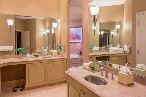 une grande salle de bains avec deux lavabos et deux miroirs dans l'établissement Sheraton Atlantic City Convention Center Hotel, à Atlantic City