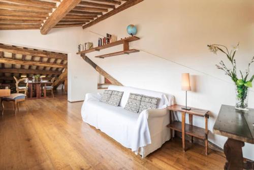 un soggiorno con letto bianco e tavolo di Pantheon Charming Penthouse a Roma