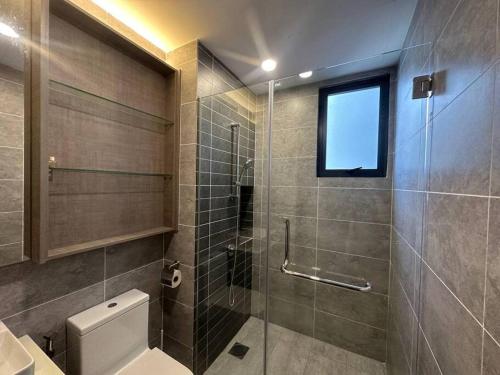 a bathroom with a shower and a toilet and a window at KL Minimalist Muji Style 3R2B in Kuala Lumpur