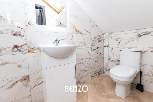 a white bathroom with a toilet and a sink at Cosy Studio Apartment in Derby by Renzo, Brilliant Location, Close to Derby City Centre in Derby