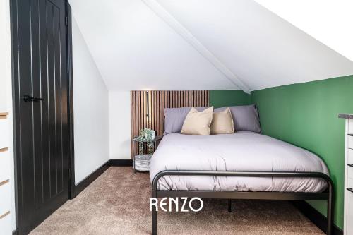 a bedroom with a bed and a green wall at Cosy Studio Apartment in Derby by Renzo, Brilliant Location, Close to Derby City Centre in Derby
