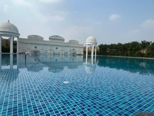 a swimming pool with a gazebo next to a building at Panaromic Perch With Swimming Pool in Lucknow