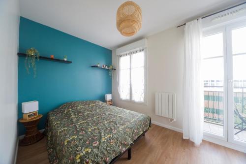 a bedroom with a bed and a blue wall at Le Libération - Paris Disney - 2 min gare in Bussy-Saint-Georges