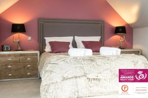 a bedroom with a large bed with pink walls at Luxury Couple's Retreat with Hot Tub at Lindores in Newburgh