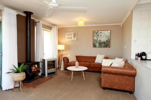 a living room with a couch and a fireplace at Sunset Balcony Bass Coast Beach House in Grantville