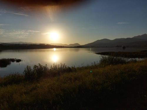a view of a lake with the sun setting at CHALUPY TRI GROŠE VLAŠKY in Bešeňová
