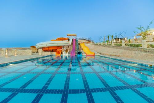 a swimming pool with a slide in the water at Siva Golden Bay Makadi in Hurghada