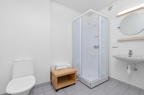 ein weißes Bad mit einer Dusche und einem Waschbecken in der Unterkunft Brekstad Gjestehus AS in Brekstad