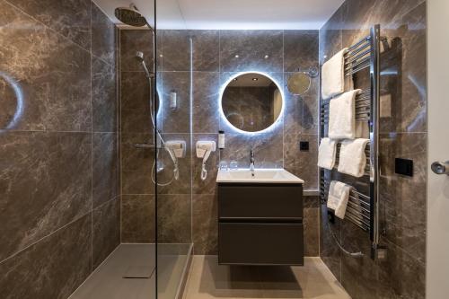 a bathroom with a shower and a sink and a mirror at ACHAT Hotel Monschau in Monschau