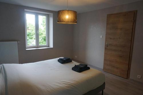 a bedroom with a bed with two black towels on it at L'Aubach - appartement spacieux in Scherwiller