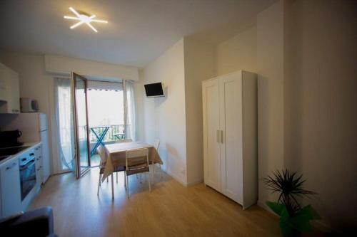 a room with a kitchen with a table and a refrigerator at Casa Primavera in Ventimiglia