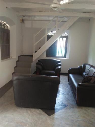 poczekalnia z kanapami i schodami w budynku w obiekcie Duwee Gadara Home stay w mieście Galle