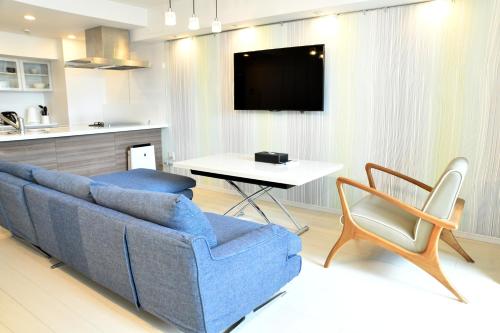 a living room with a blue couch and a table at Hotel Axas Nihonbashi in Tokyo