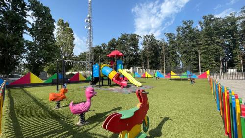 a playground with colorful play equipment in a park at Mona Hotel and Cottages in Lankaran
