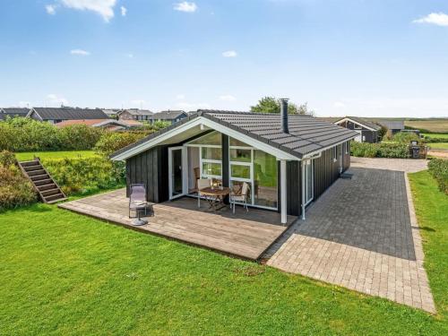une petite maison avec une terrasse dans une cour dans l'établissement Holiday Home Tanna - 330m to the inlet in Western Jutland by Interhome, à Lemvig
