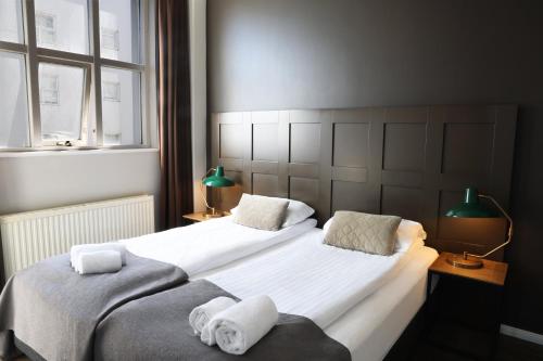 a bedroom with two beds with towels on them at Fosshotel Baron in Reykjavík