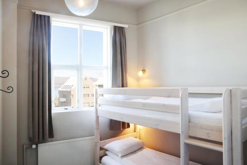 a bedroom with two bunk beds and a window at Fosshotel Baron in Reykjavík