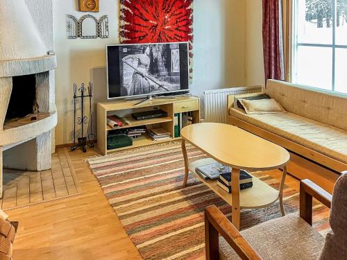 een woonkamer met een bank en een tv bij Holiday Home Ylläskakkonen b9 by Interhome in Ylläsjärvi