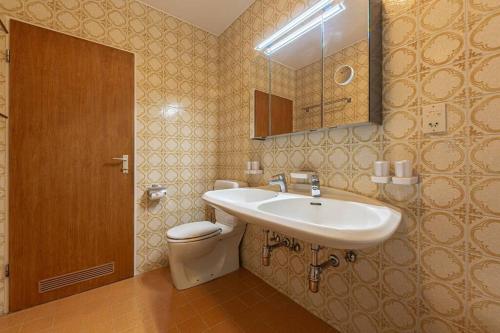 La salle de bains est pourvue d'un lavabo, de toilettes et d'un miroir. dans l'établissement Gipfelblick Residenz #2, à Kitzbühel