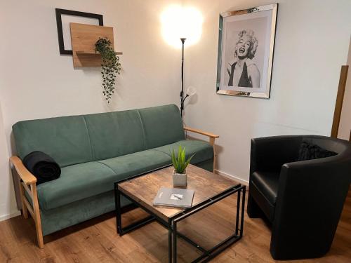 a living room with a green couch and a table at Apartment Glockner-1 by Interhome in Heiligenblut