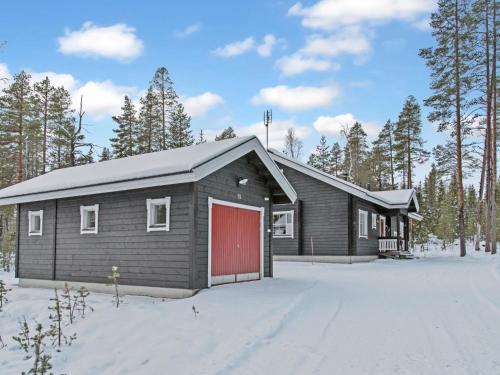 eine Hütte mit einer roten Tür im Schnee in der Unterkunft Holiday Home Luppo by Interhome in Ylläsjärvi