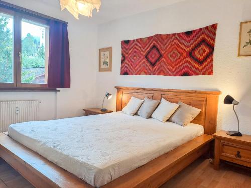 a bedroom with a large bed with a wooden headboard at Apartment Galaxie 217 by Interhome in Verbier