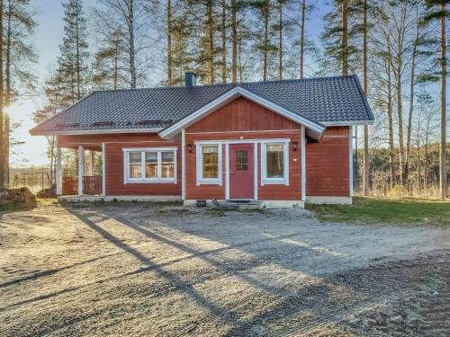 a small red house with a red door at Holiday Home Sanninpirtti by Interhome in Niskamäki