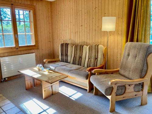 ein Wohnzimmer mit einem Sofa, 2 Stühlen und einem Tisch in der Unterkunft Apartment Colline 3 by Interhome in Champex