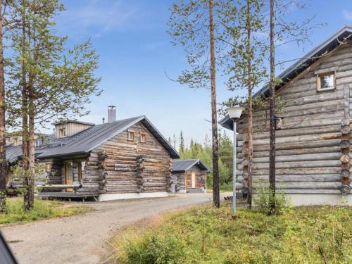 a log cabin next to a road next to a house at Holiday Home Kukasrakka c10 by Interhome in Äkäslompolo