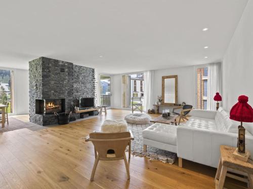 a living room with a white couch and a fireplace at Apartment Triangel Raber by Interhome in Parpan