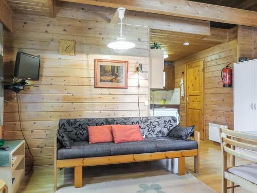 ein Sofa in einem Zimmer mit einer Holzwand in der Unterkunft Holiday Home Lomamaja 3 by Interhome in Raattama