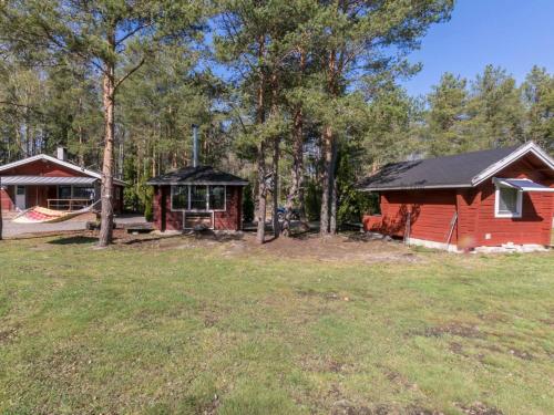 a log cabin and a playground in the woods at Holiday Home Jarsala by Interhome in Töfsala