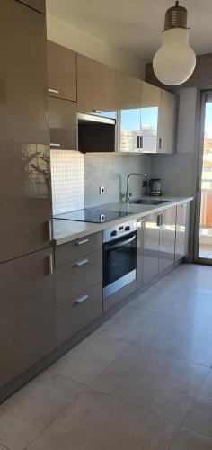 - une cuisine avec des placards en acier inoxydable et une cuisinière dans l'établissement Bel Appartement plein centre Nice, à Nice