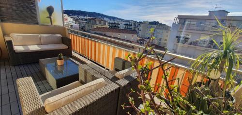 - un balcon avec un canapé et une table dans un bâtiment dans l'établissement Bel Appartement plein centre Nice, à Nice