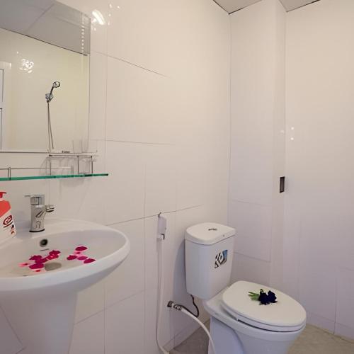 a white bathroom with a toilet and a sink at Cua Dai Beach Homestay in Hoi An