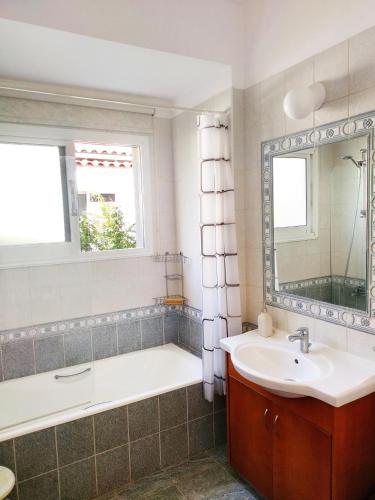 a bathroom with a tub and a sink and a mirror at Villa Talassa with optional HEATED POOL, JACUZZI and 4x4 CAR in Peyia