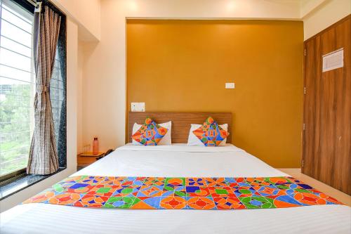 a bedroom with a large bed with a colorful comforter at FabHotel Royal Hospitality in Pune