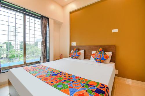 a bedroom with a bed and a large window at FabHotel Royal Hospitality in Pune