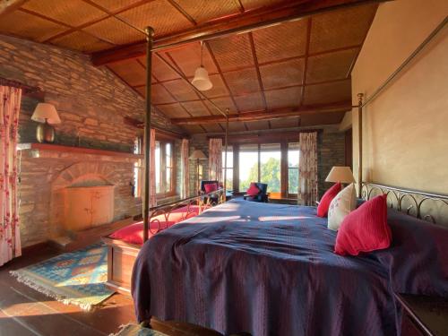 a bedroom with a large bed in a room with a fireplace at Nine Furlongs, Binsar Wildlife Sanctuary in Almora
