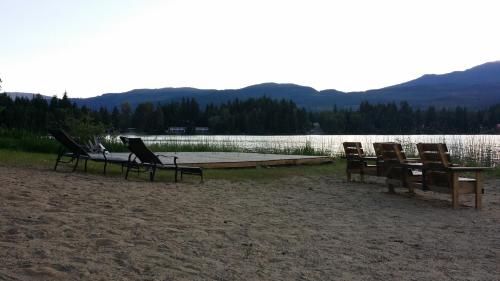 a group of chairs sitting on a beach next to a lake at Hotel Civilia Lakeside by Civilia Golf Retreat in Clearwater