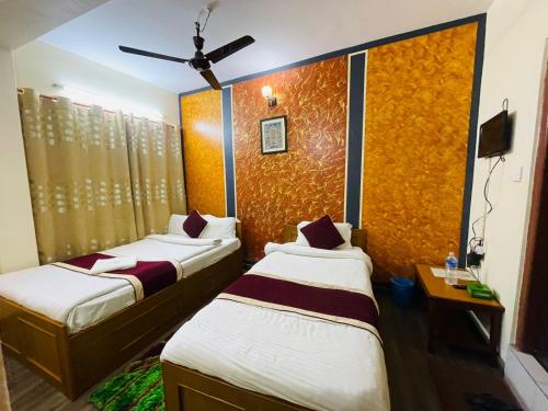 博卡拉Hotel old durbar的一间有两张床和一台电视的酒店房间