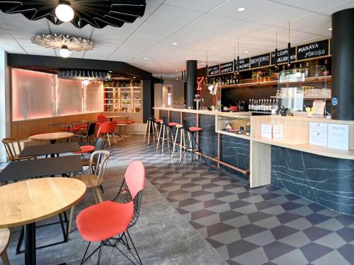 een restaurant met tafels en stoelen en een bar bij ibis Auxerre Centre in Auxerre