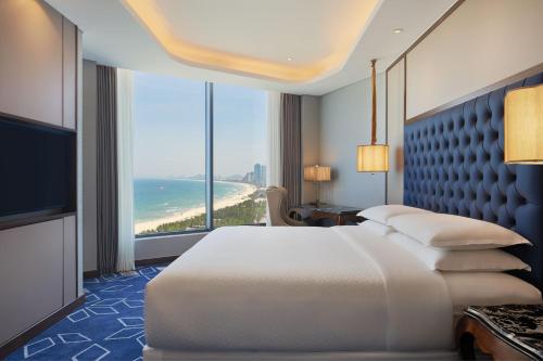 a bedroom with a bed and a view of the ocean at Four Points by Sheraton Danang in Danang