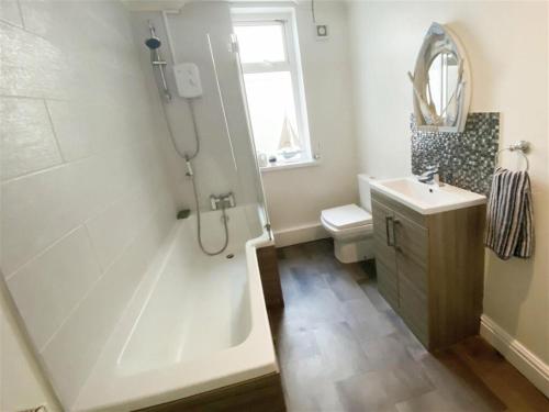 uma casa de banho com um chuveiro, uma banheira e um lavatório. em The Gateway a lovely Spacious Seaside Property close to the beaches , centrally located in Porthcawl em Newton
