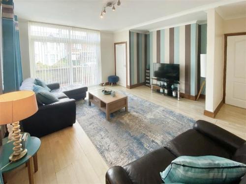 uma sala de estar com dois sofás e uma televisão em The Gateway a lovely Spacious Seaside Property close to the beaches , centrally located in Porthcawl em Newton