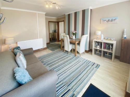 a living room with a couch and a table at The Gateway a lovely Spacious Seaside Property close to the beaches , centrally located in Porthcawl in Newton