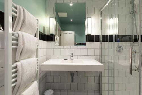 a white bathroom with a sink and a mirror at Wynn's Hotel in Dublin